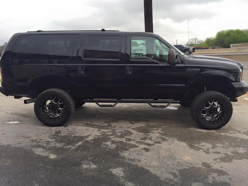 A black suv is parked on the side of the road.