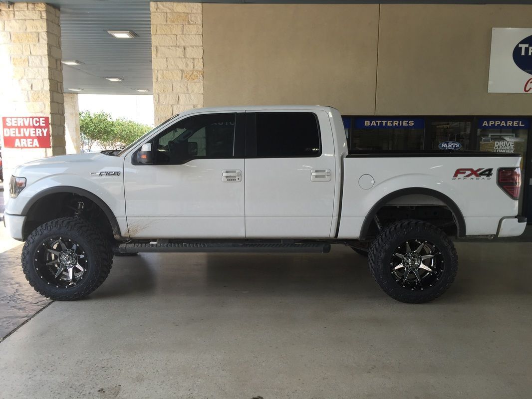 A white pickup truck is parked in front of a building.