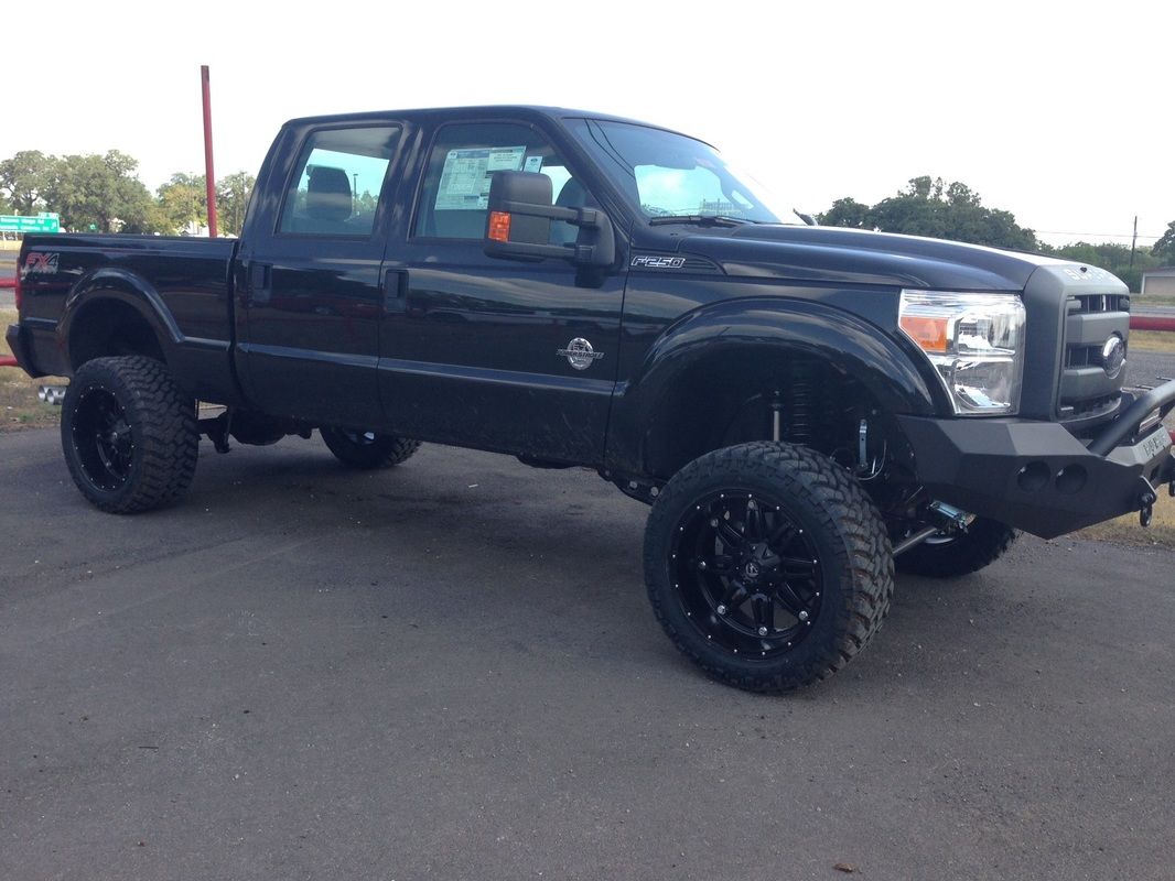 A black truck is parked on the side of the road.