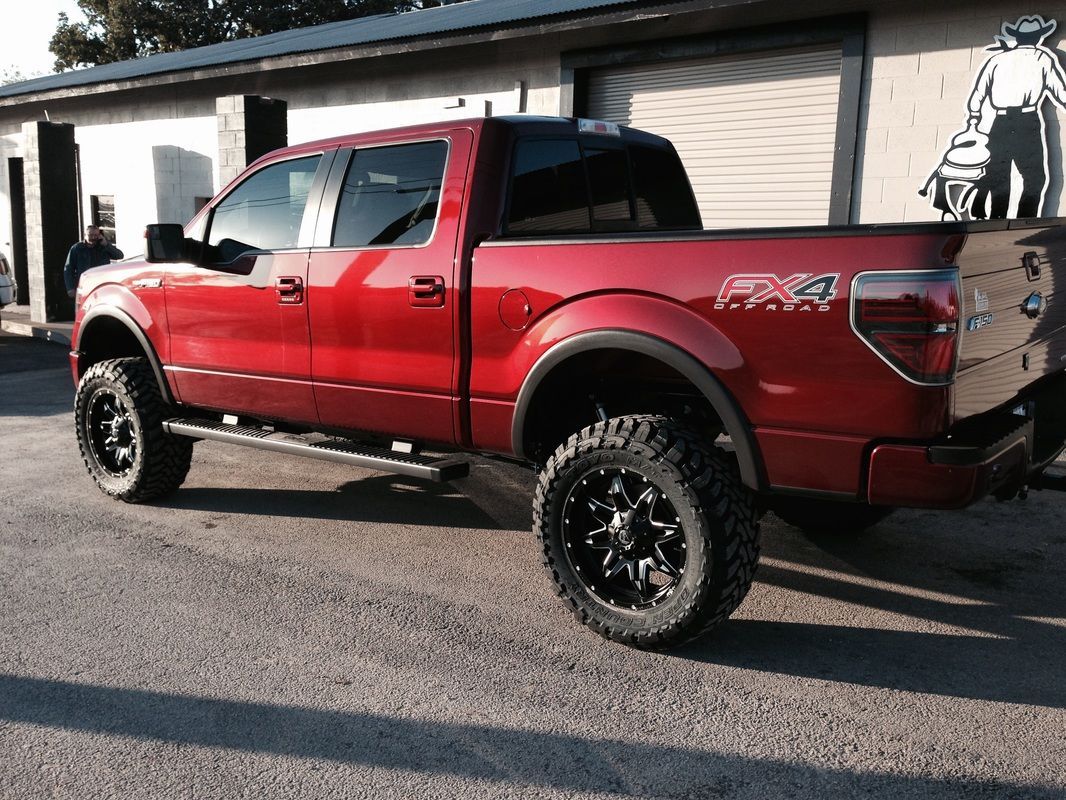 A red truck is parked in front of a building