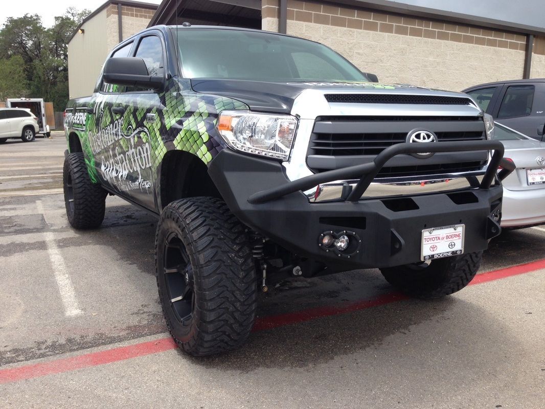 A black truck is parked in a parking lot