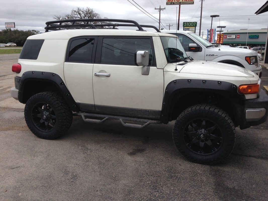 A white toyota fj cruiser is parked in a parking lot.