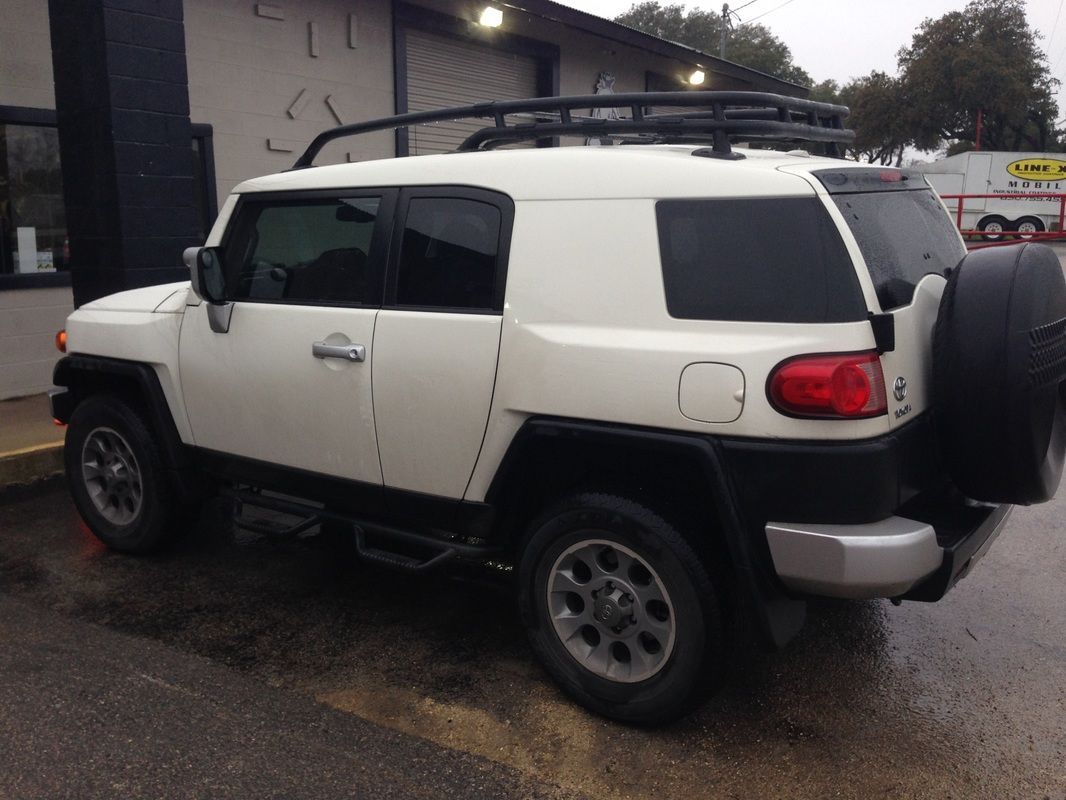 A white toyota fj cruiser is parked in a parking lot