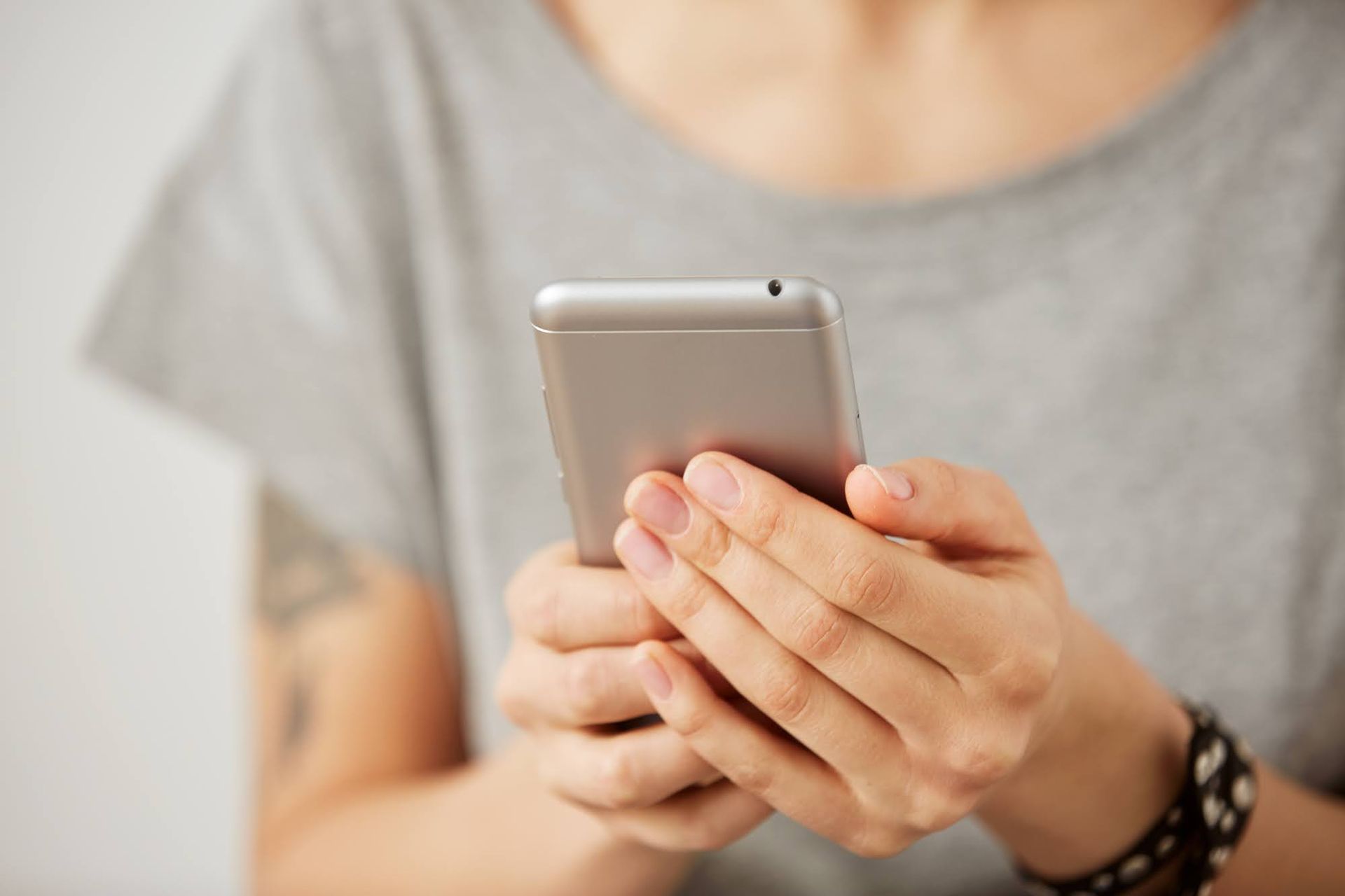 A woman is holding a cell phone in her hands.
