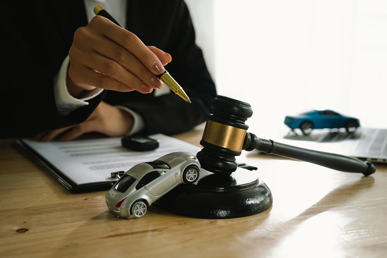 A lawyer uses a gavel near a toy car. A lawyer uses a gavel near a toy car.