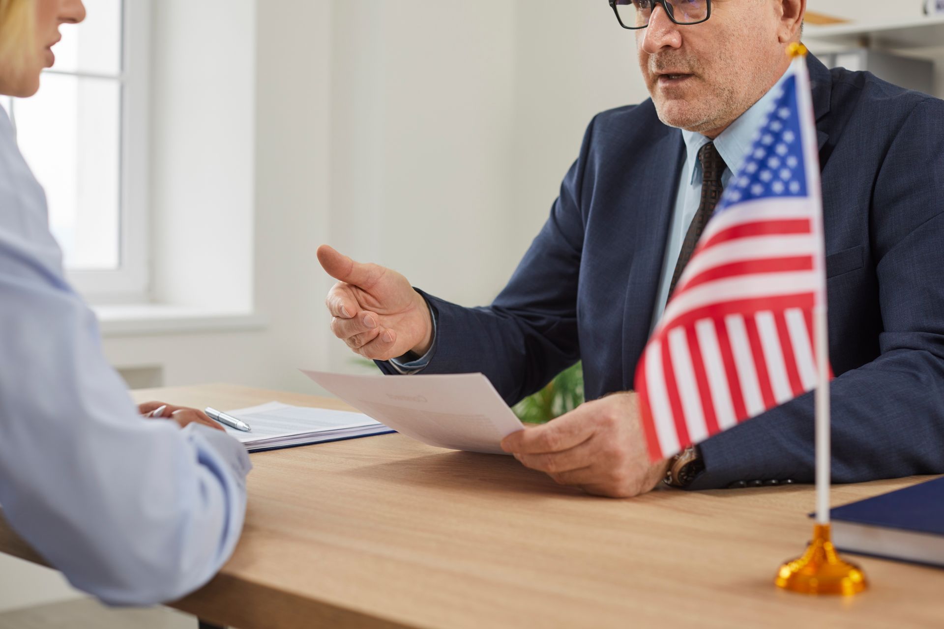 A visa application lawyer discussing case details at an office desk.