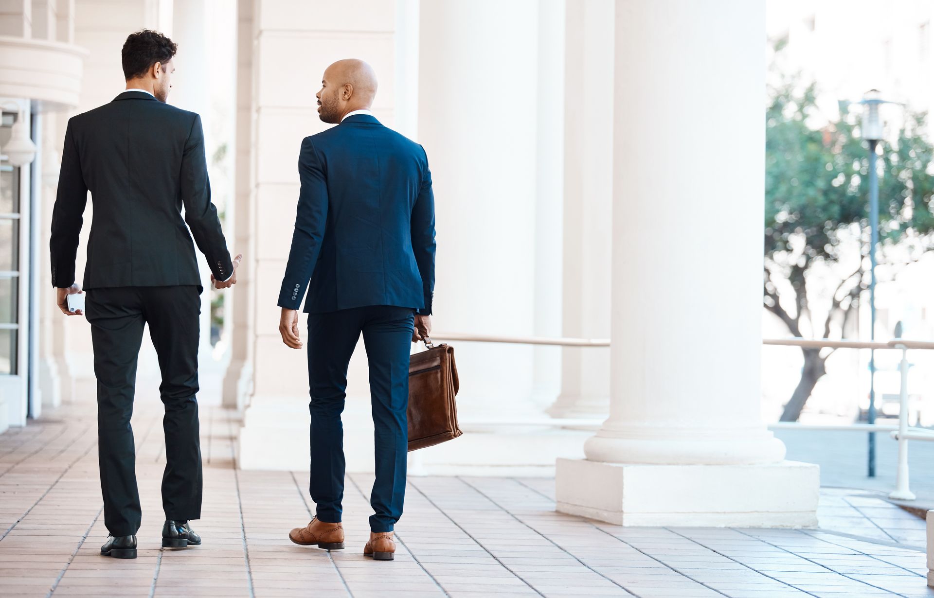 A visa application lawyer consulting with a client outside a government building. A visa application lawyer consulting with a client outside a government building.