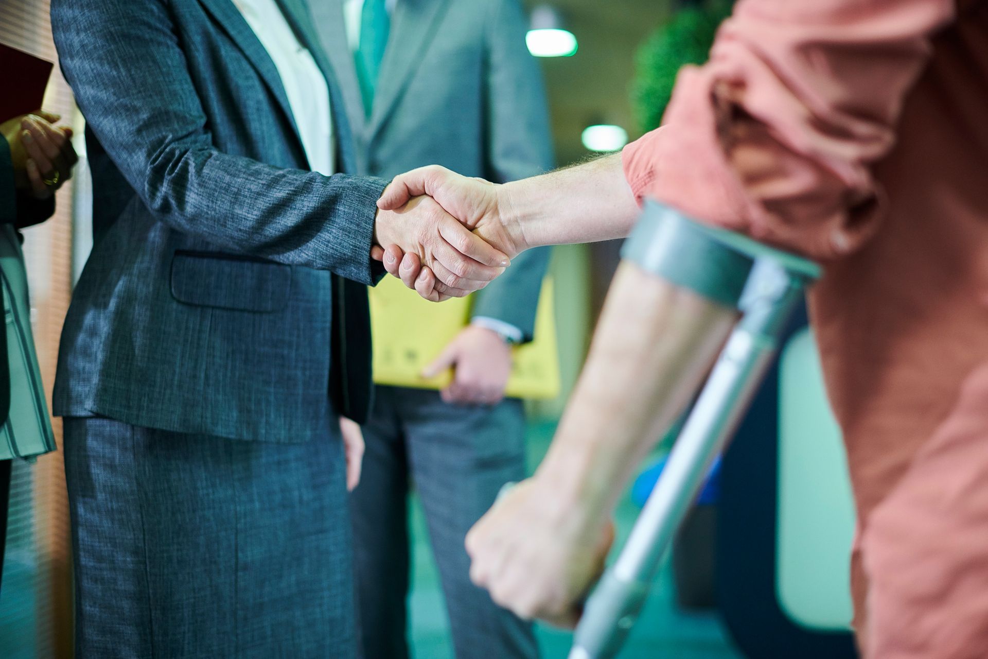 Cropped view of a man on crutches greeting an accident attorney.