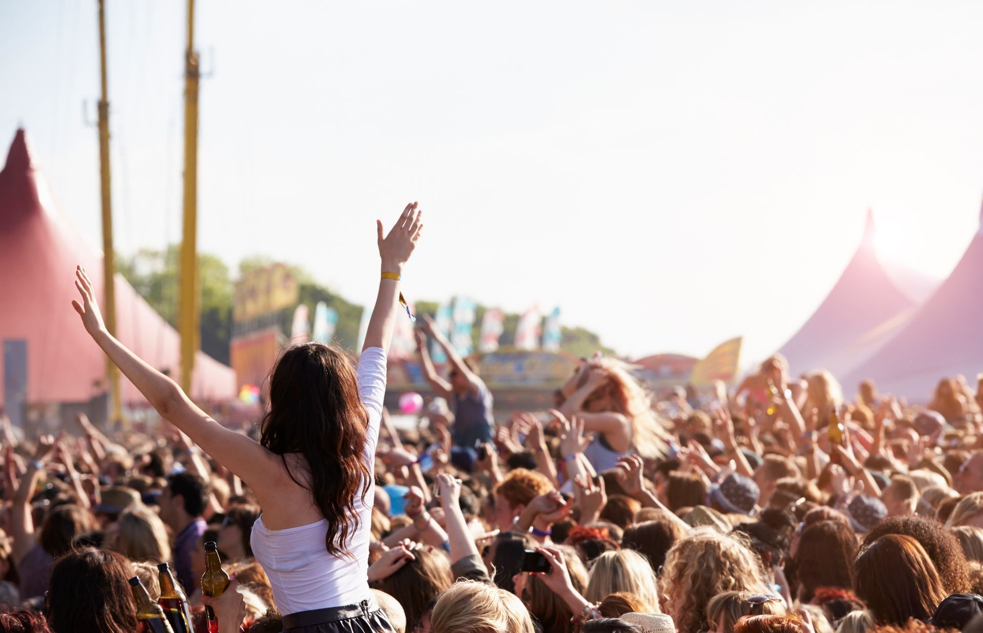 A woman is standing in front of a crowd of people at a music festival.