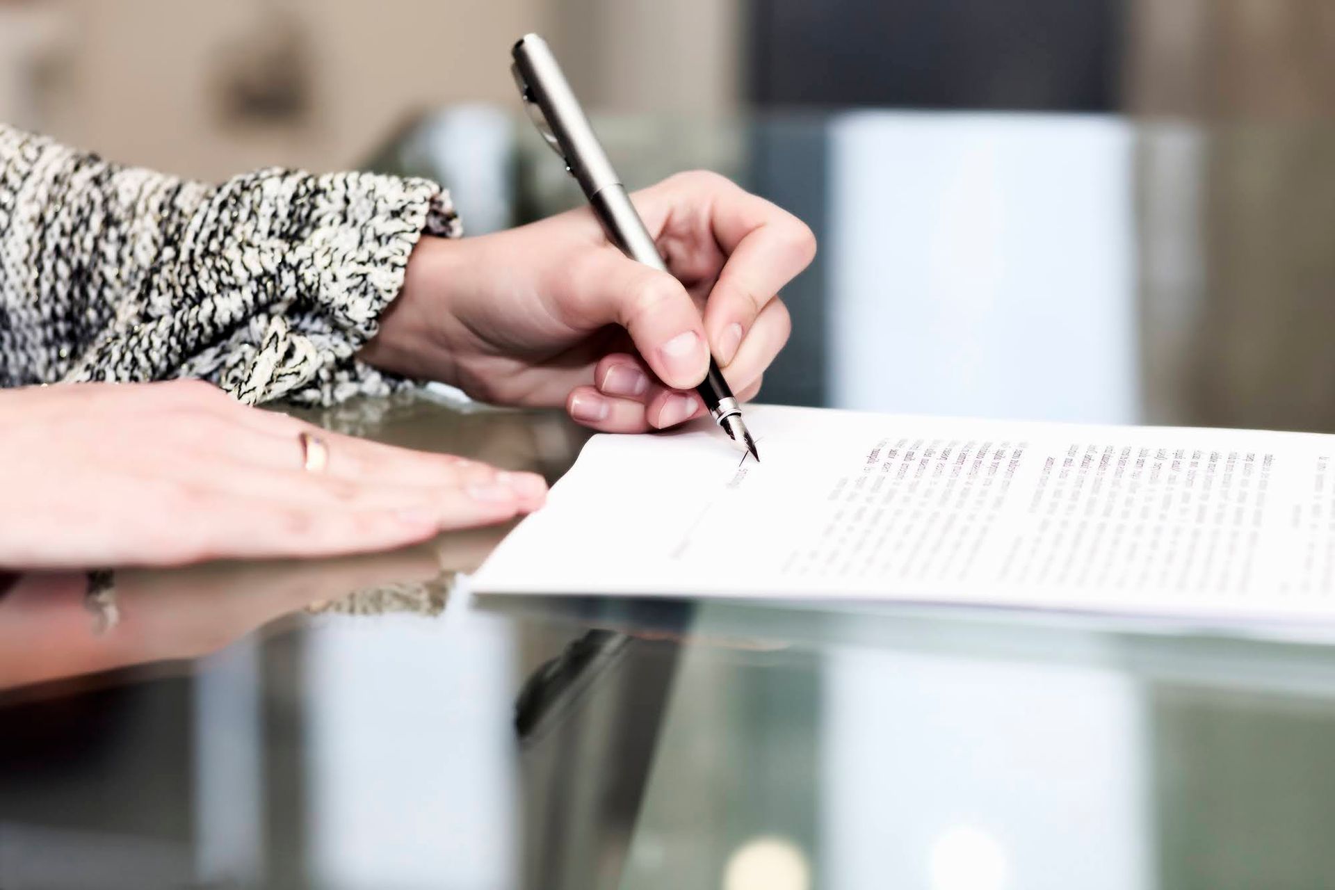 A person is writing on a piece of paper with a pen.