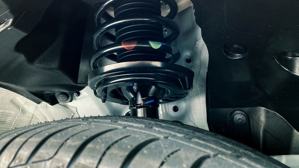 A Close Up of a Shock Absorber and a Tire on a Car — Fix-It Automotive in Unanderra, NSW