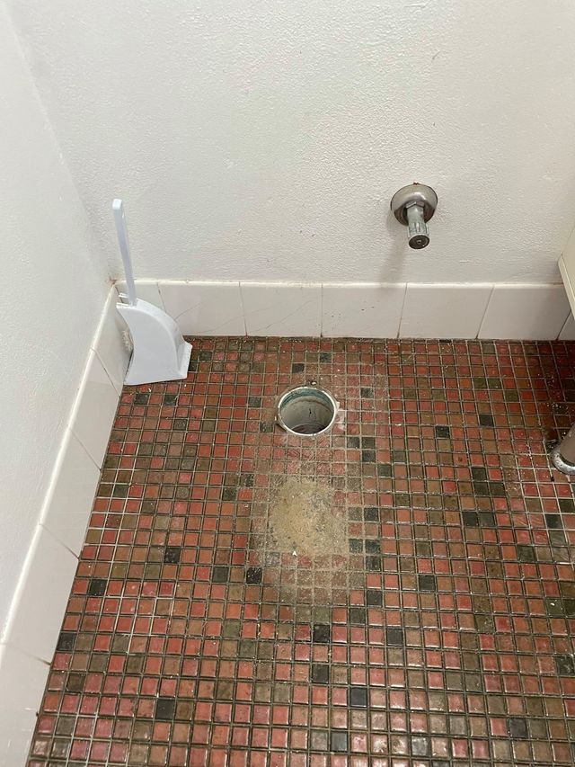 A Bathroom Floor With Red and Black Mosaic Tiles — Expert Plumbing & Solar Services Bathurst in Orange, NSW