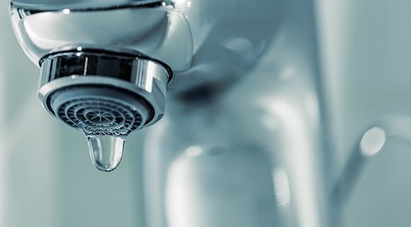 a Close-up of a Chrome Faucet With a Single Water Droplet — Expert Plumbing & Solar Services Bathurst in Kelso, NSW