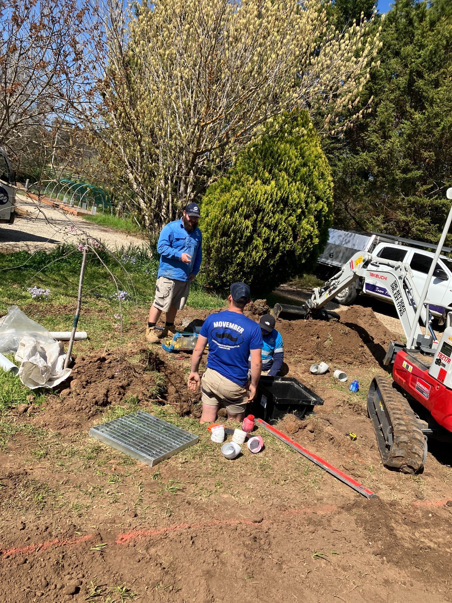 Two People Install Drainage With Equipment on a Hillside — Expert Plumbing & Solar Services Bathurst in Oberon, NSW