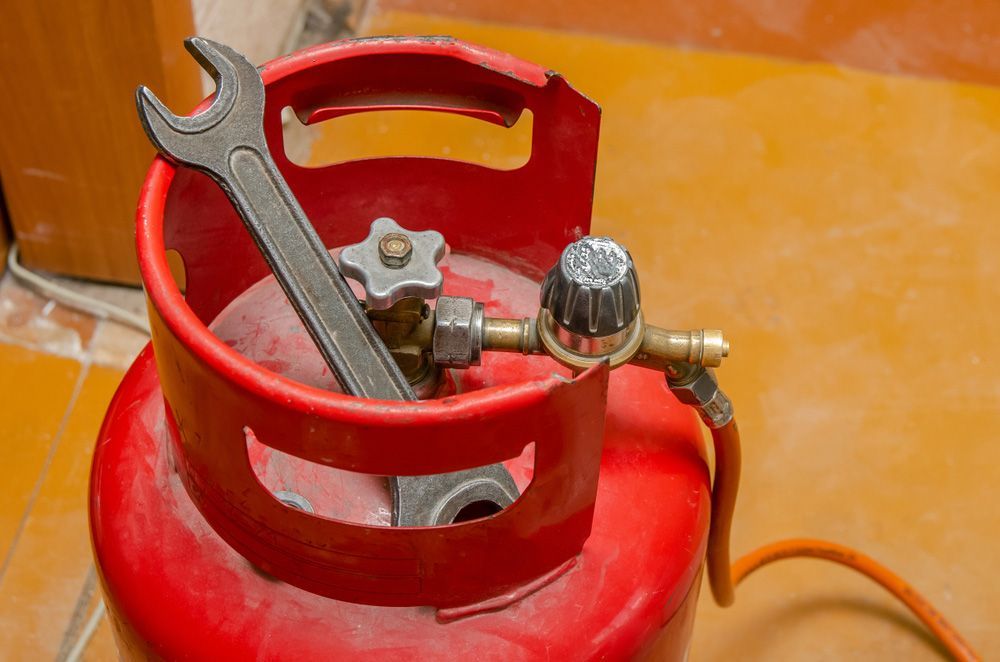 Red Propane Tank With a Wrench and Regulator — Expert Plumbing & Solar Services Bathurst in Kelso, NSW