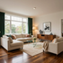 Bright modern living room with beige sectional, glass coffee table, wood floor, and large window with green curtains