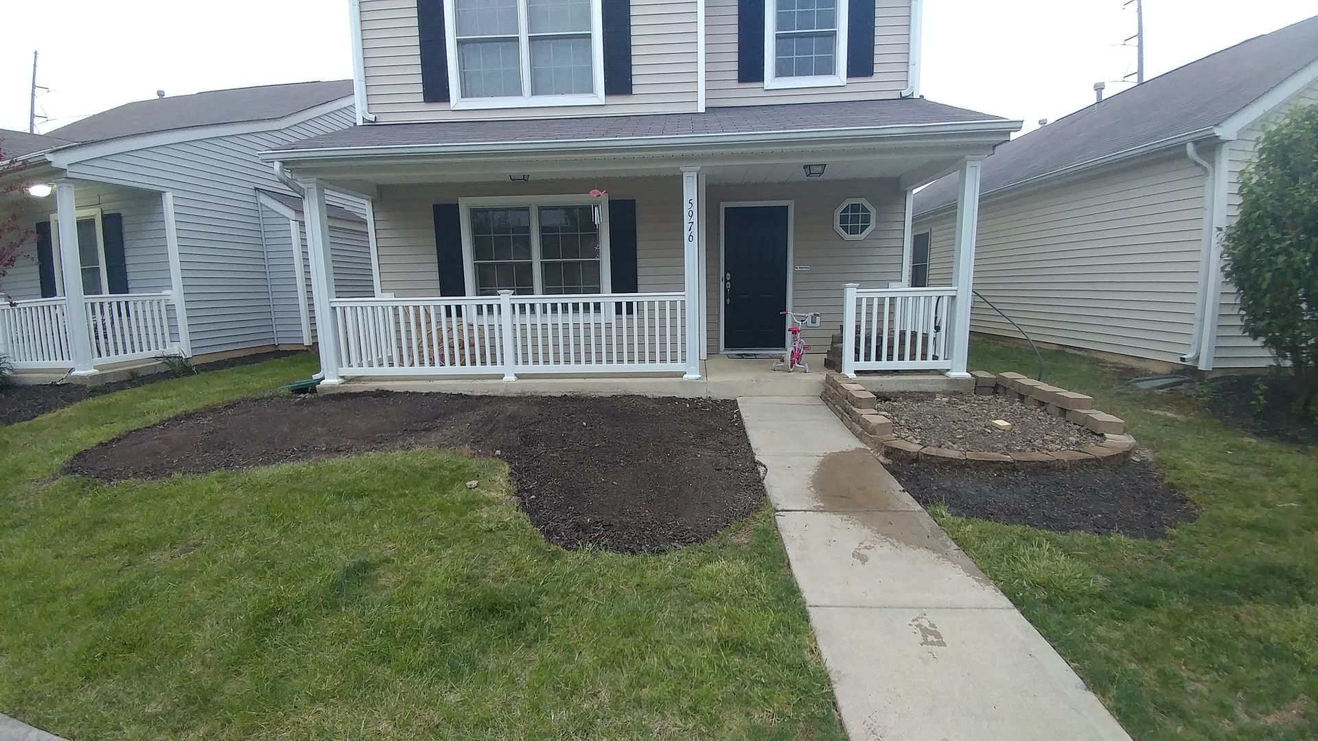 A house with a porch and a walkway leading to it.