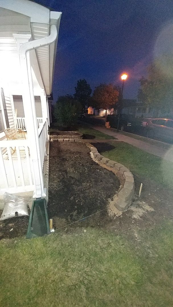 A house is lit up at night and there is a street light in the background.