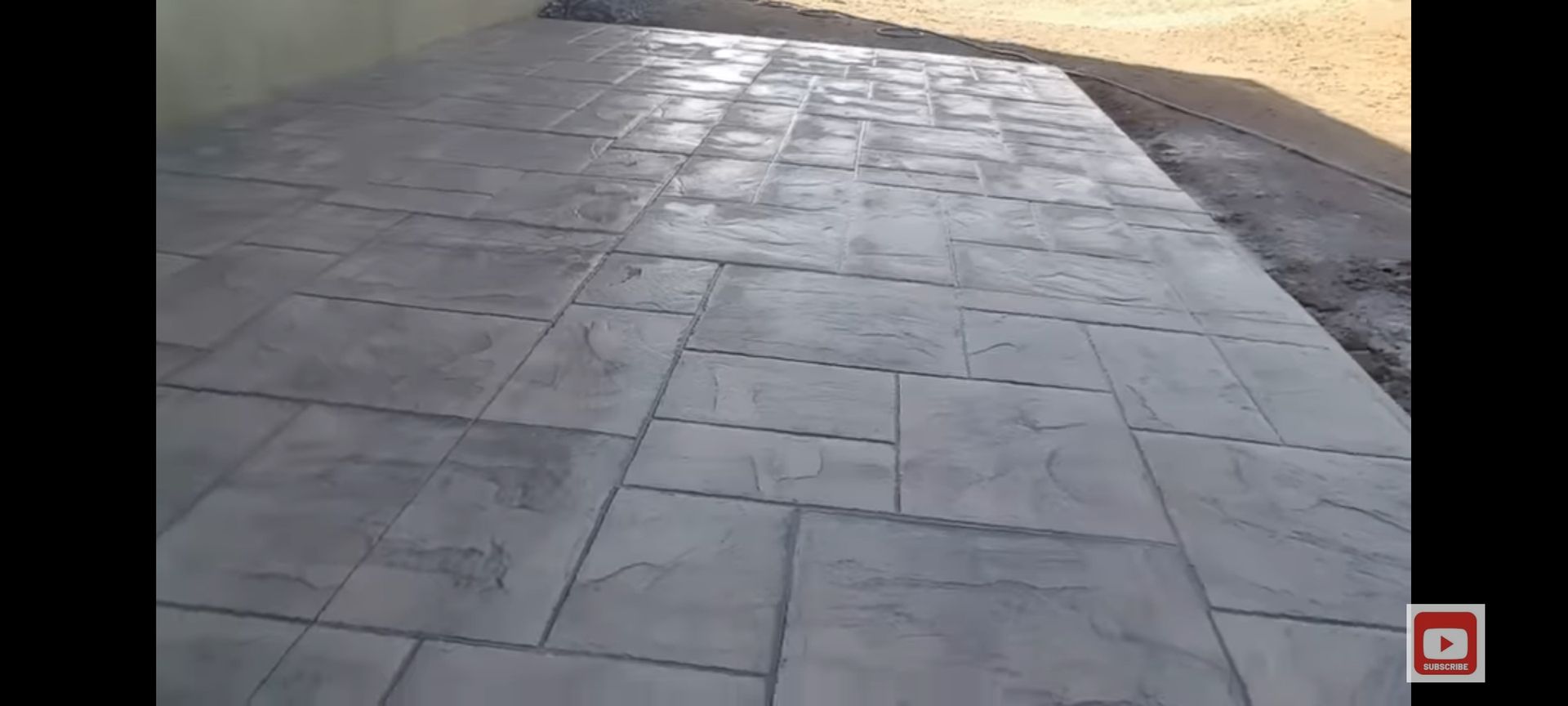 A paved patio with gray textured concrete in a rectangular pattern.