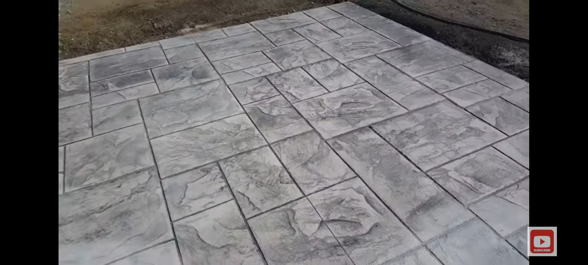 Stamped concrete patio with a flagstone pattern. Gray. Outdoors.