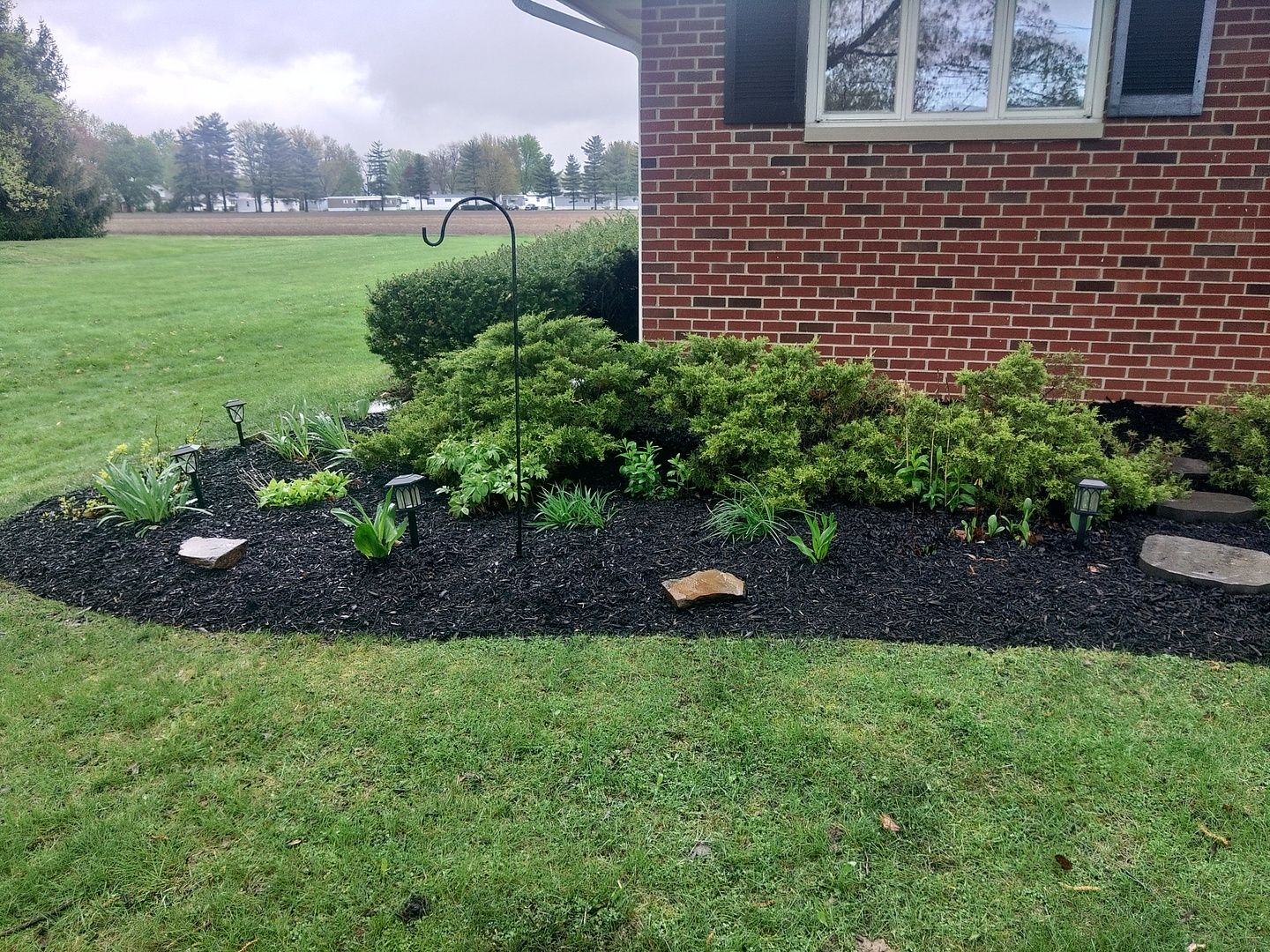 A brick house with a garden in front of it.