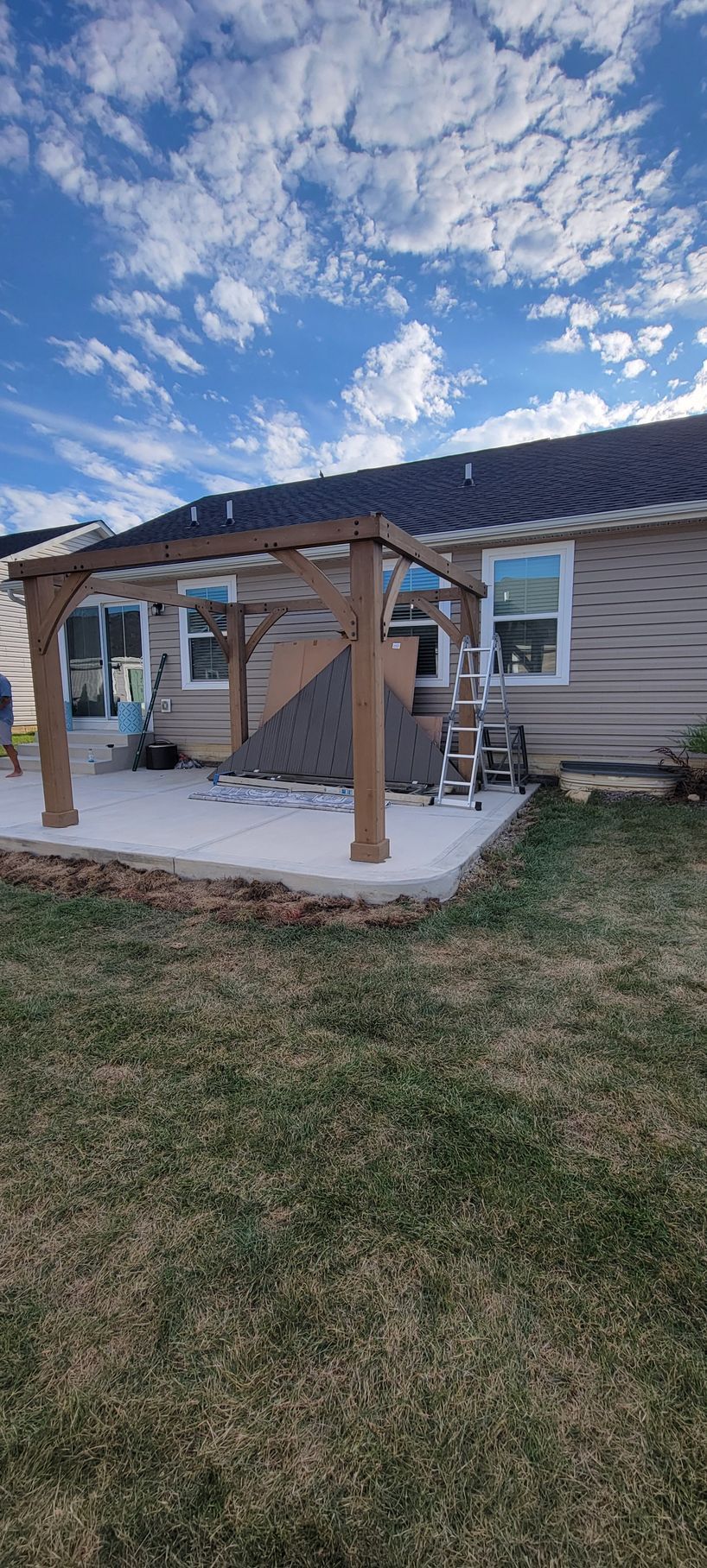 There is a pergola in the backyard of a house.
