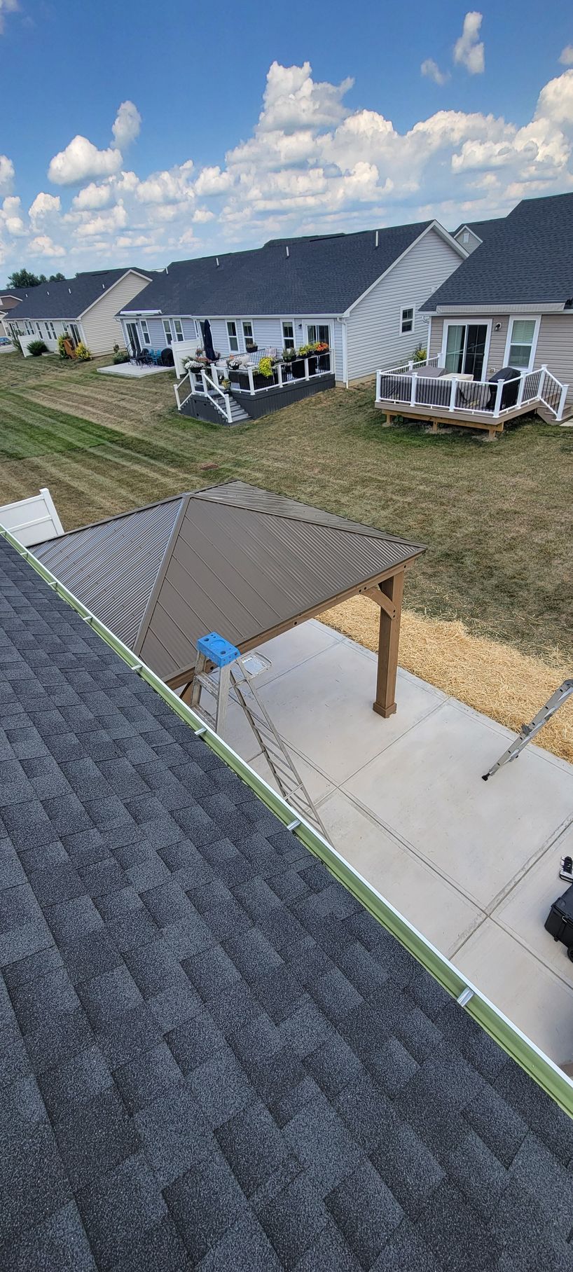An aerial view of a roof with a gazebo in the middle of a residential area.
