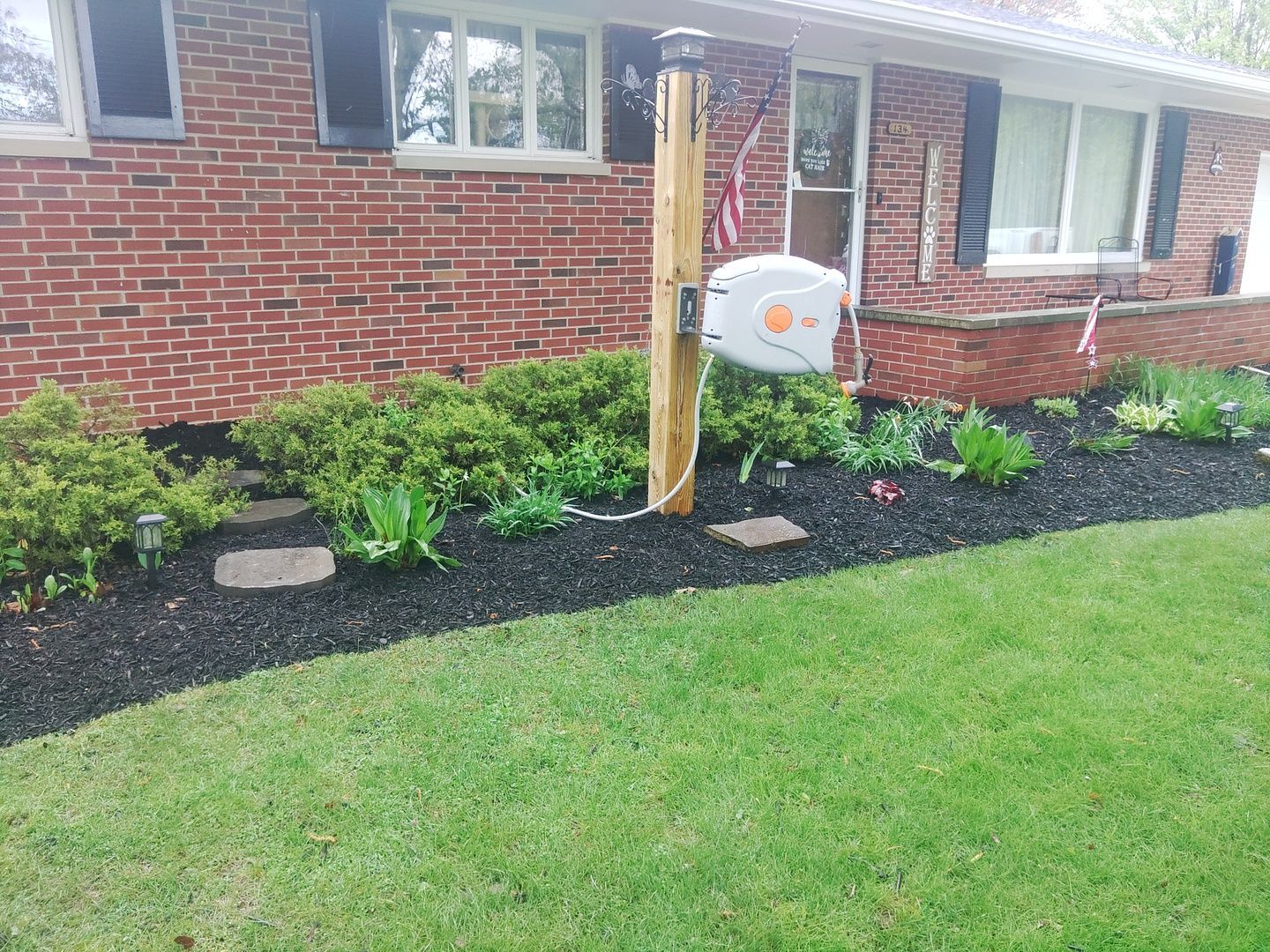 A brick house with a wooden post in front of it.