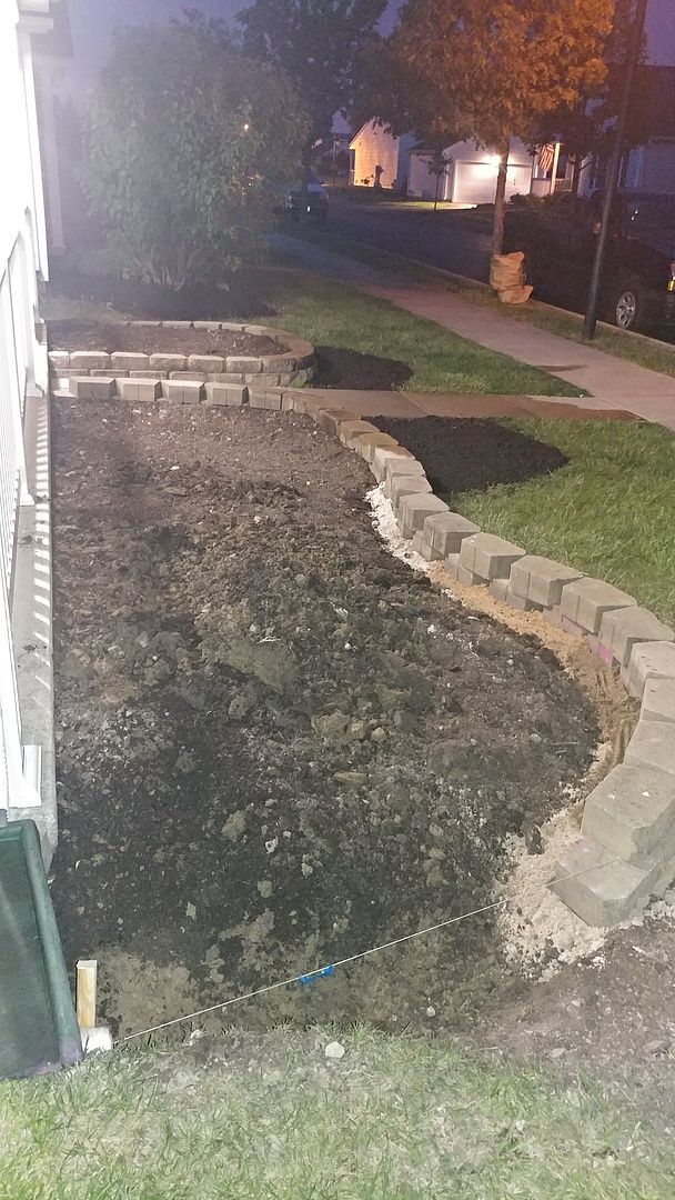 A sidewalk is being built in front of a house at night.