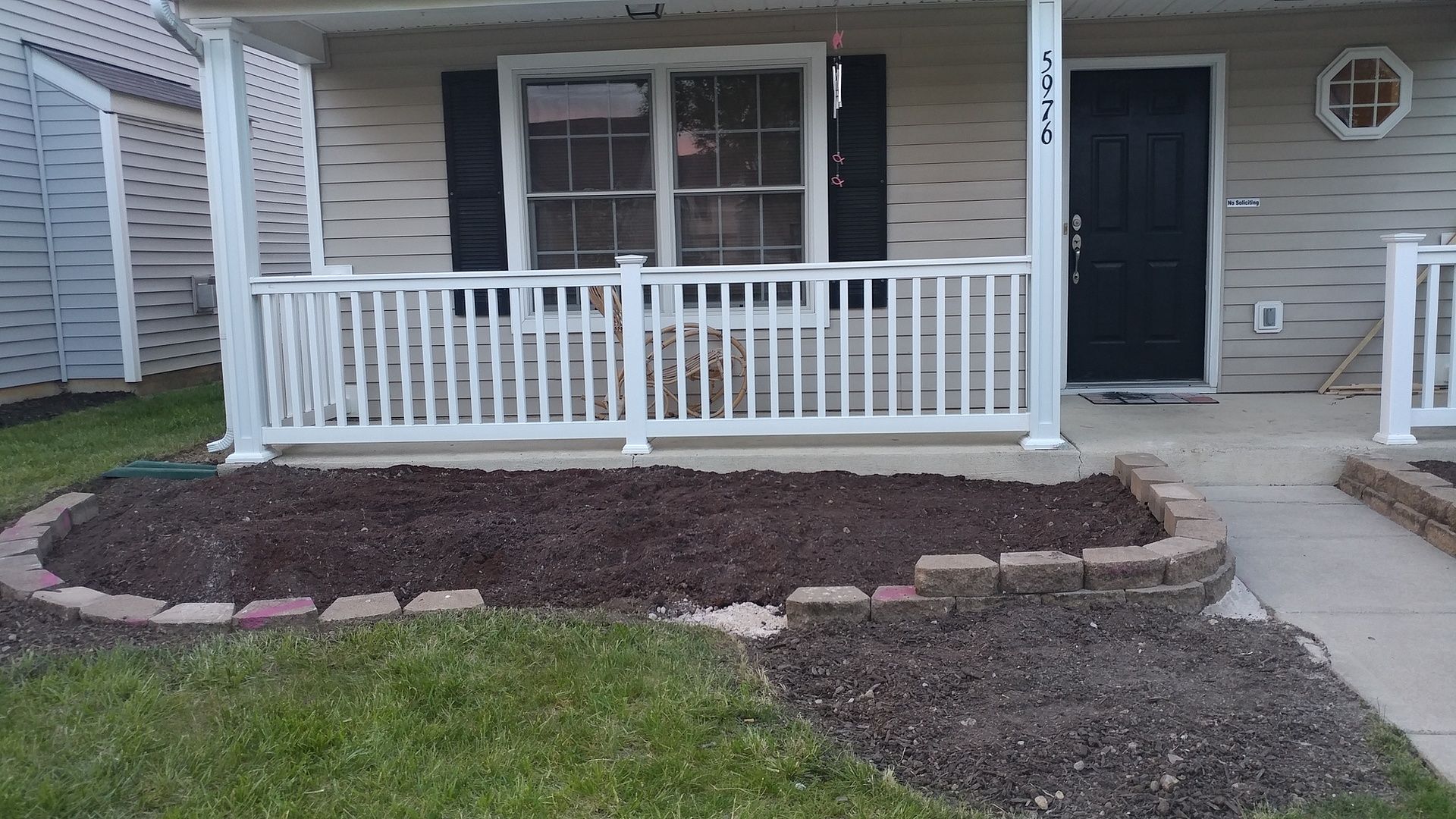 A house with a porch and a black door
