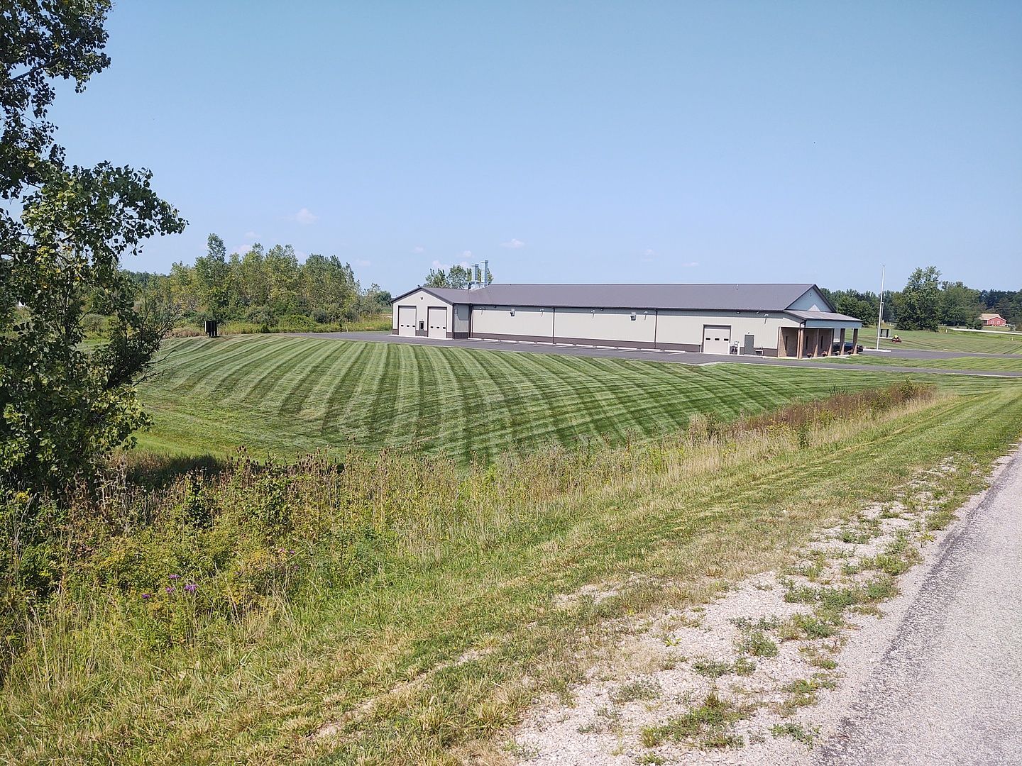 A large building sits in the middle of a grassy field