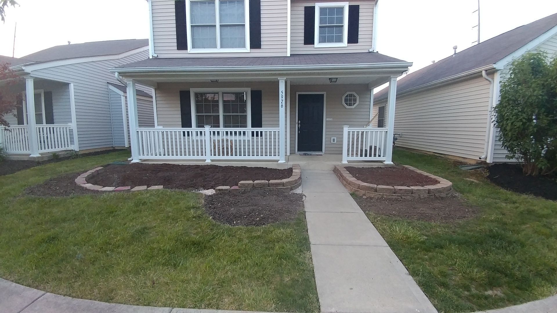 A house with a porch and a walkway in front of it.