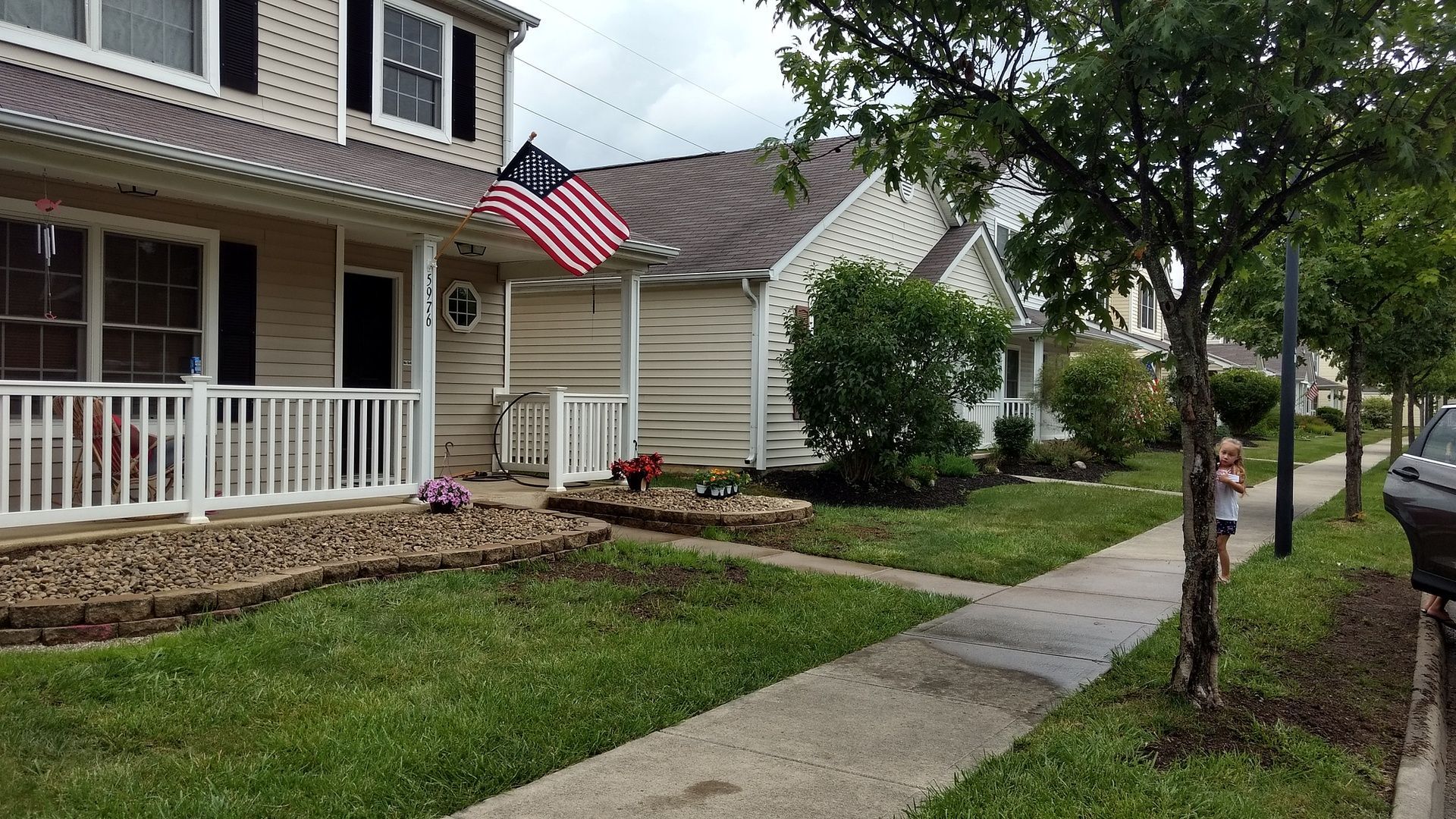 A house with a porch and an american flag on it.