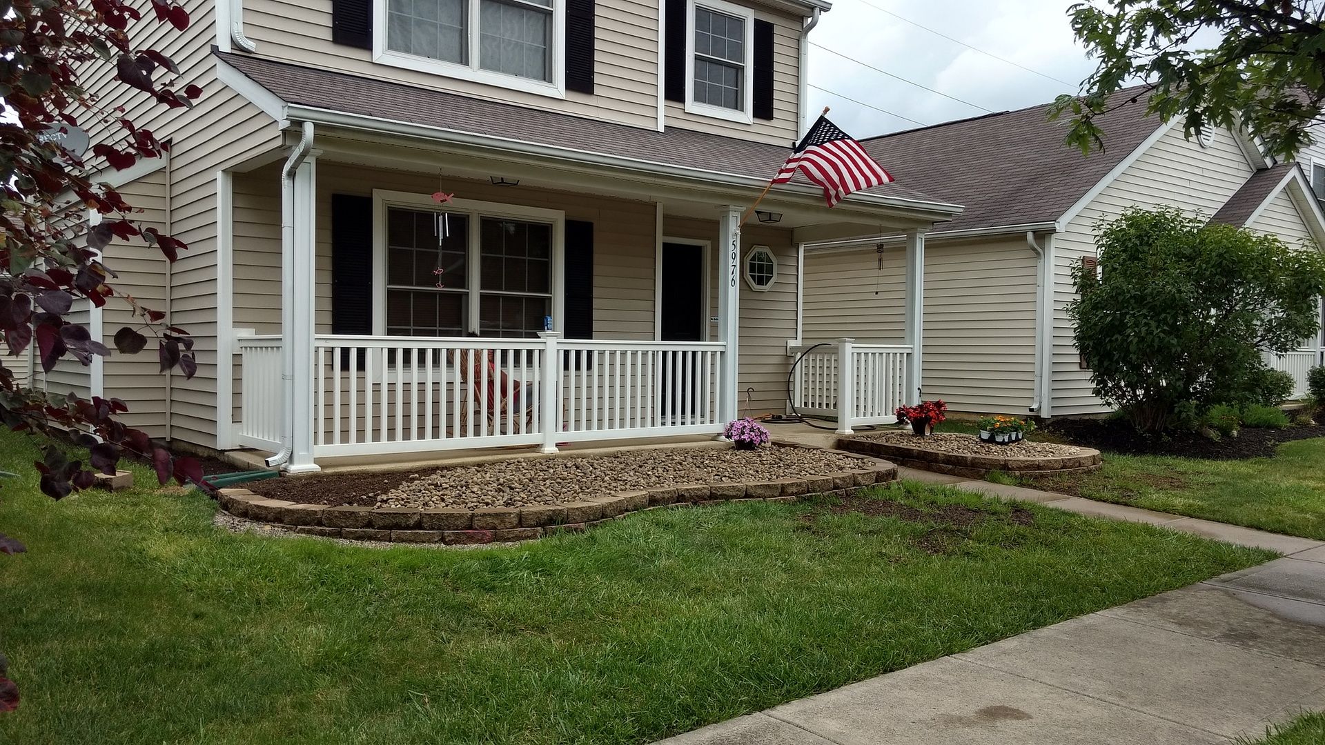 A house with a porch and an american flag on it