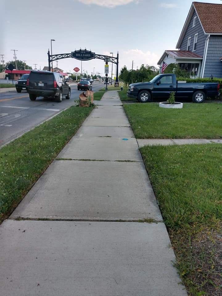 A sidewalk with cars parked on the side of it