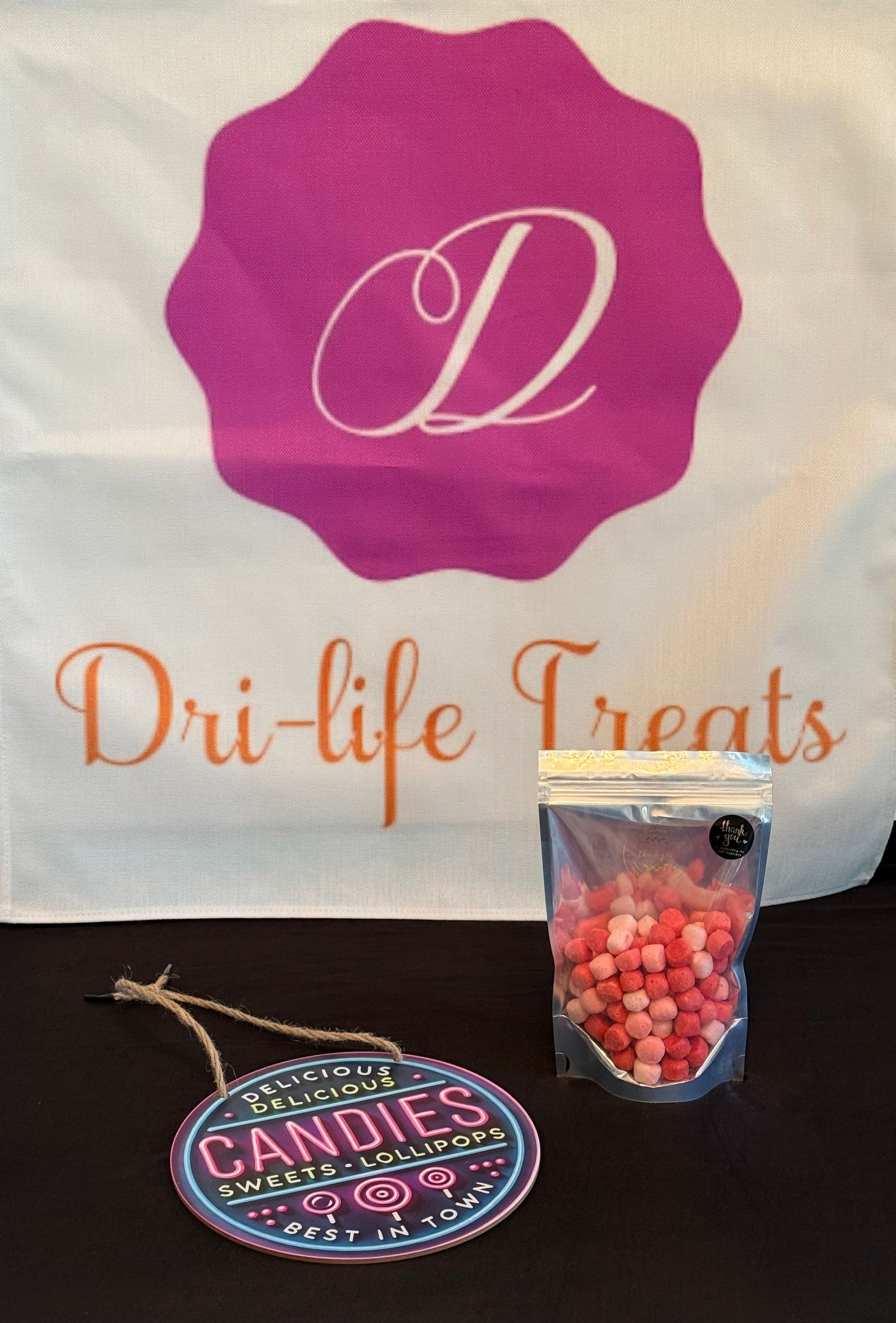 Dri-life Treats logo banner with a candy bag and a small cup of pink candies on a table