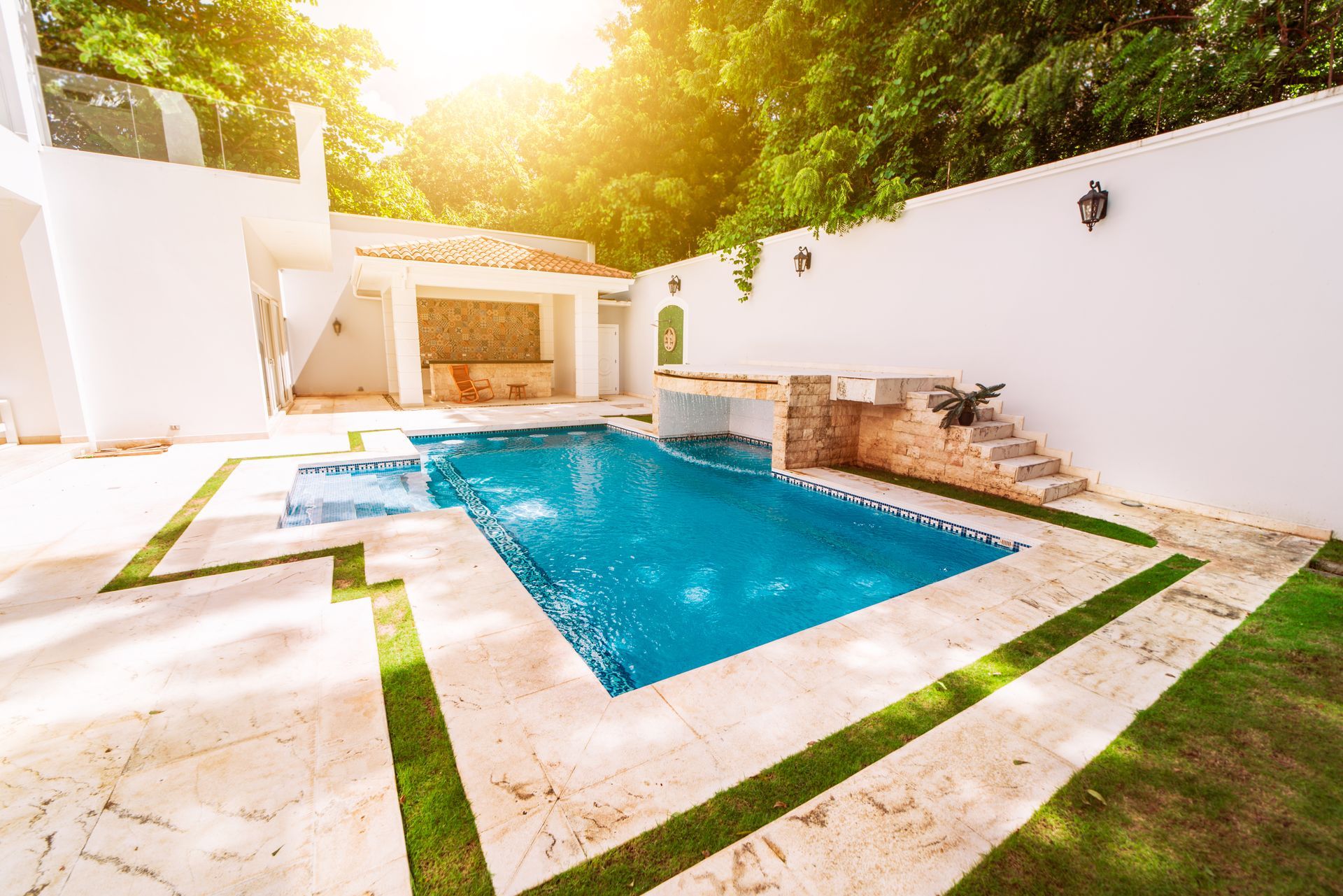 Pool overlooking a lake, surrounded by screen enclosure, plants, and patio.
