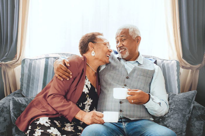 Senior couple enjoys coffee on a couch together