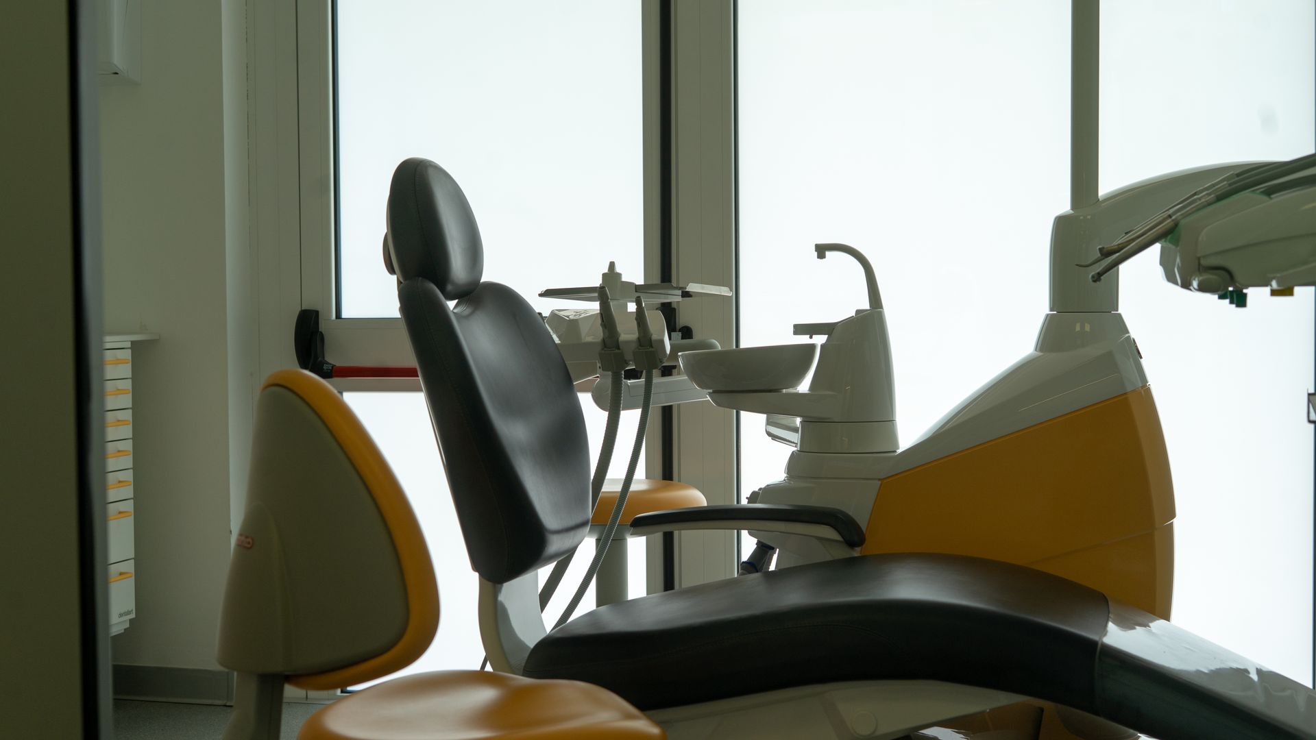 Clinica odontoiatrica con poltrone e attrezzature moderne in una luminosa sala per i trattamenti.
