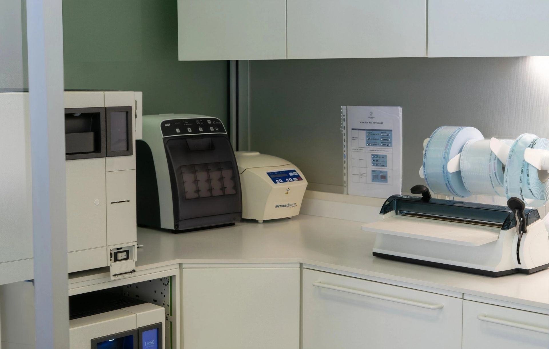 Banco da lavoro clinico con apparecchiature da laboratorio medico, tra cui una centrifuga e analizzatori, in un ambiente di lavoro pulito.