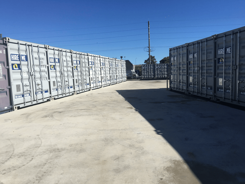 Rows of shipping containers available for hire at an outdoor storage facility.
