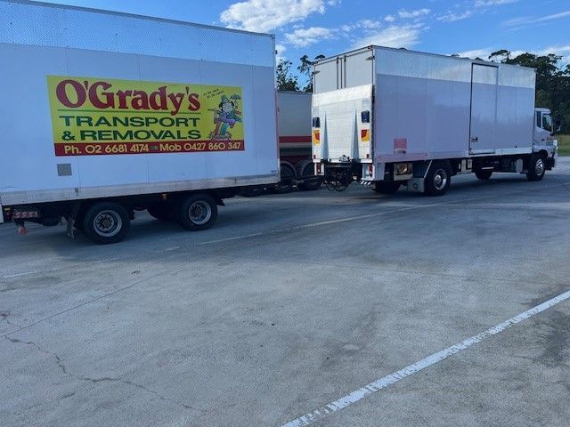 A Moving Van is Parked in Front of a Brick House — O'Grady's Transport & Removals in Yamba, NSW