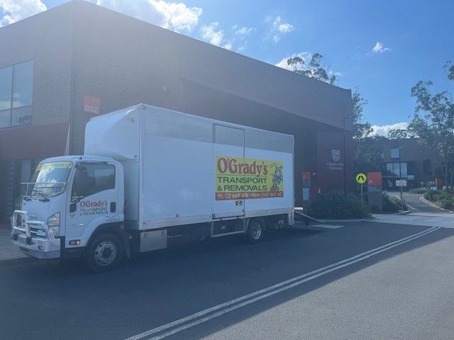 A Man is Loading Boxes Into a Van — O'Grady's Transport & Removals in Alstonville, NSW