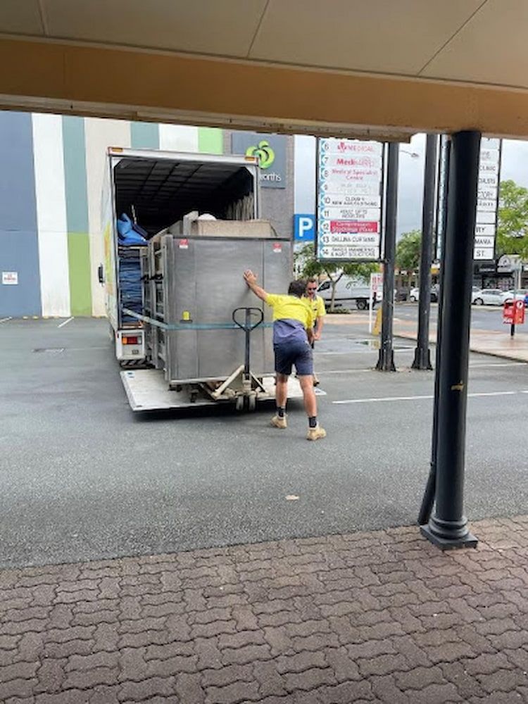 Moving Truck With Ramp Down, Loaded With Furniture and Boxes in a Driveway — O'Grady's Transport & Removals in Byron Bay, NSW