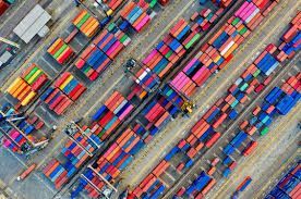 Aerial view of stacked colorful shipping containers in a busy cargo yard