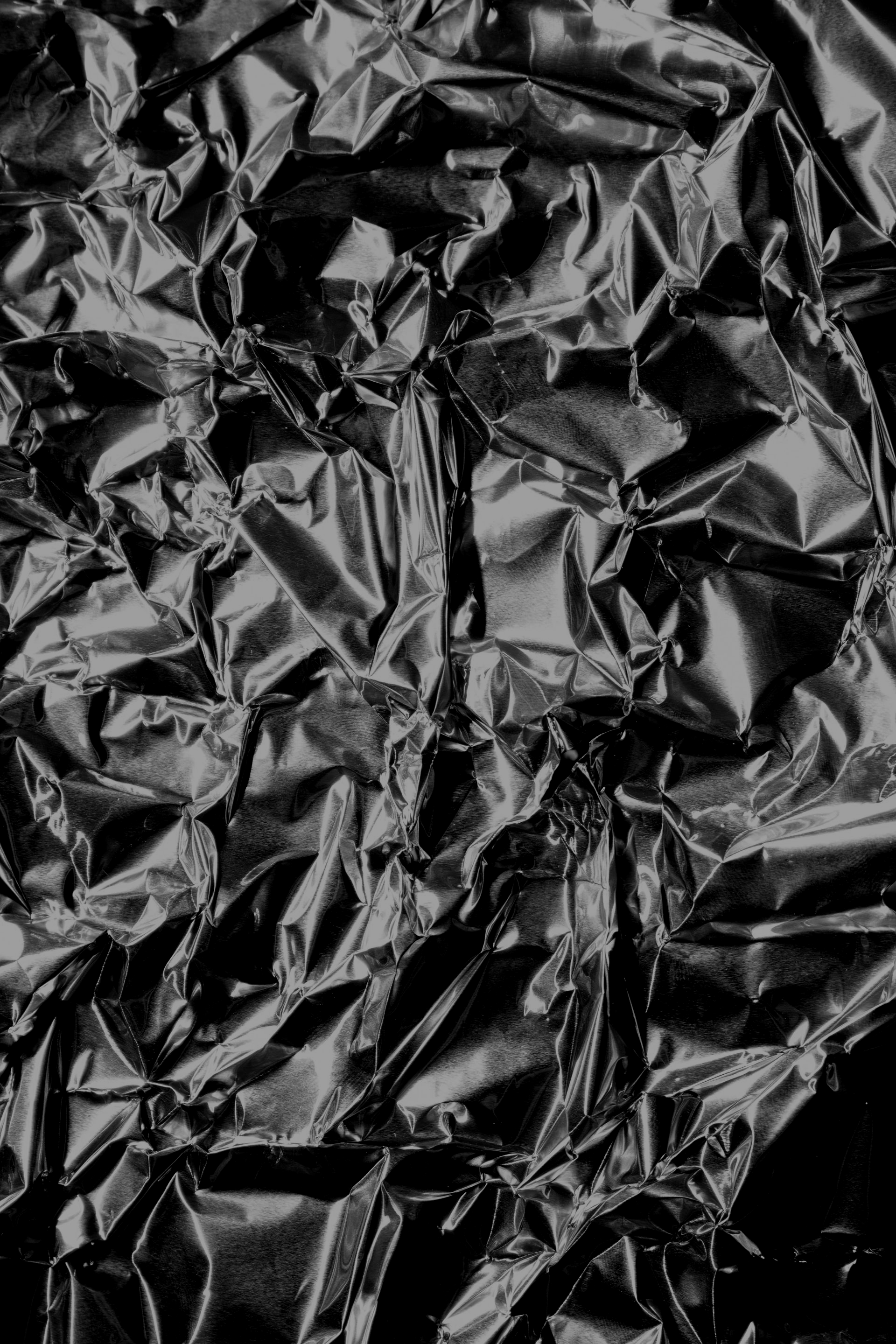 Crinkled black plastic or foil texture filling the frame