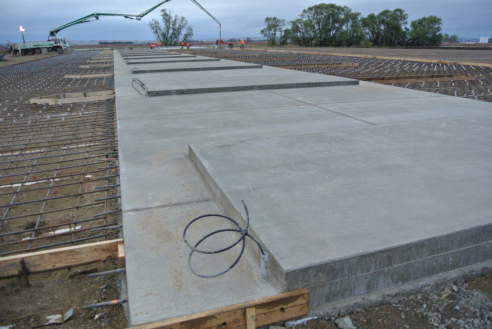 A large concrete slab is being poured on a construction site