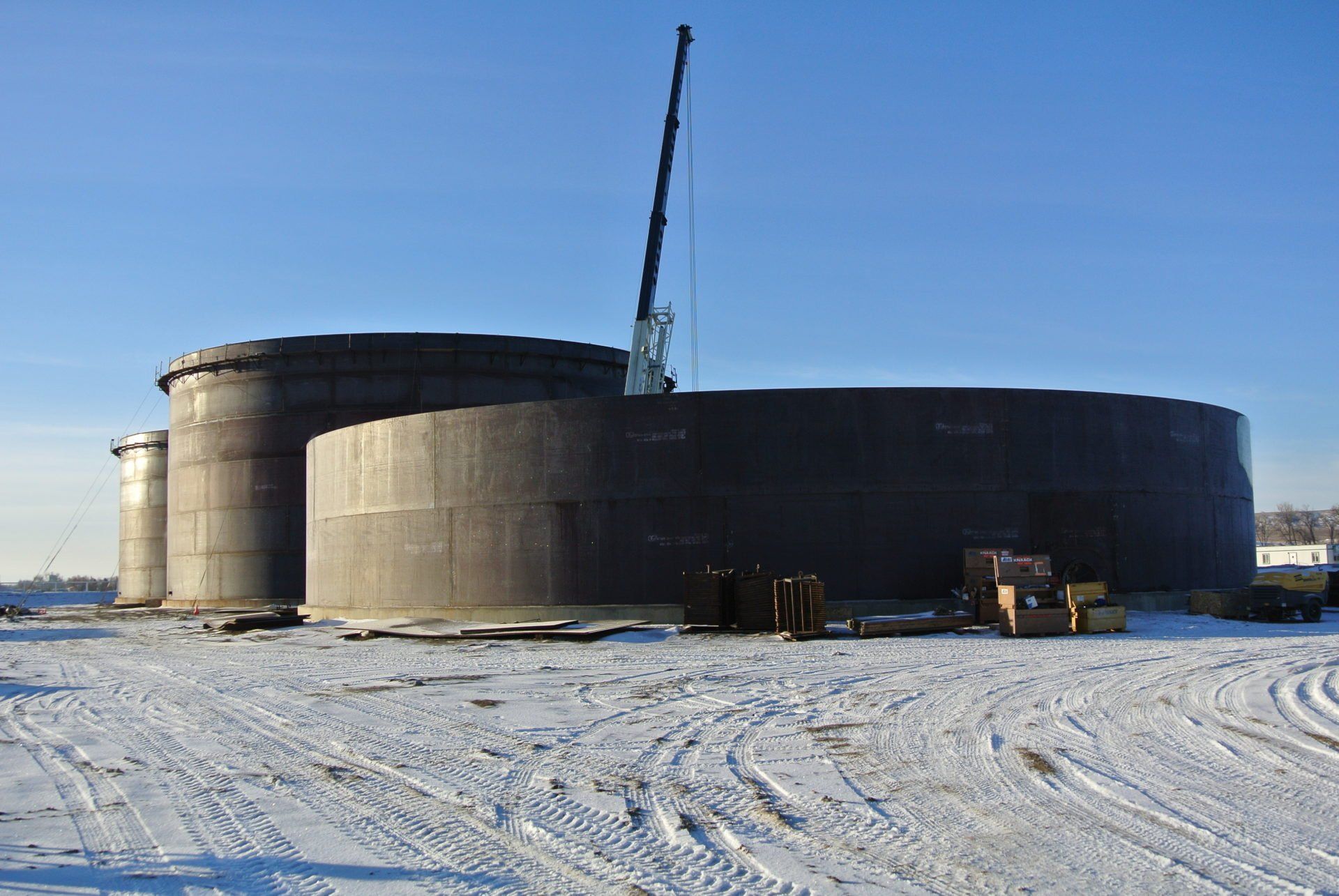 A large metal structure is being built in the snow