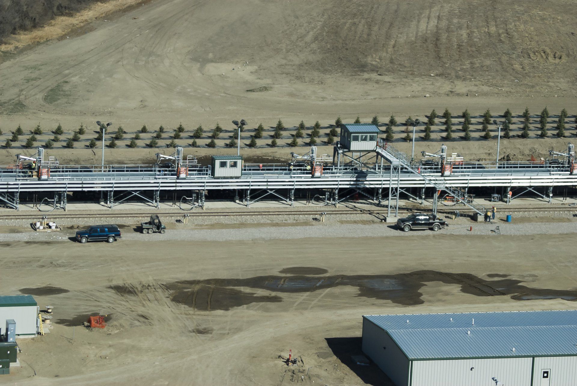 An aerial view of a construction site with a fence in the background