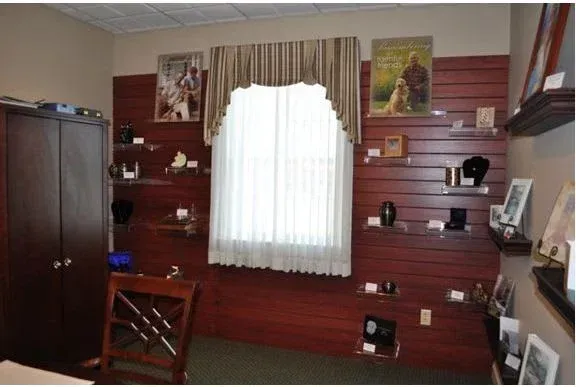 A room with shelves and a window with pictures on the wall